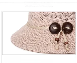 Close-up of beige summer sun hat featuring hollow knit texture and wooden buttons