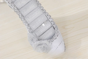 Detail of silver sequin high heel ring holder with floral accent and soft storage slots