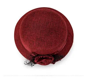 Close-up of dark red linen sun hat with elegant satin rose and dotted mesh veil