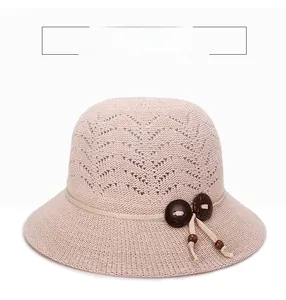 Detailed crochet hollow pattern and wooden buttons on a pink summer sun hat