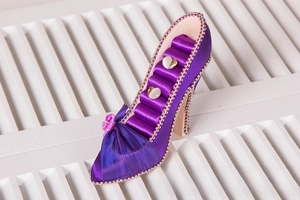 Detailed side view of purple satin high heel jewelry stand for rings and earrings