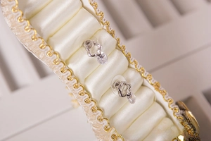 Macro view of silver-plated flower earrings with round diamonds on satin display