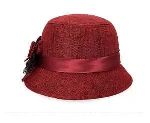 Detailed side view of a vintage burgundy cloche hat with textured fabric and satin floral bow