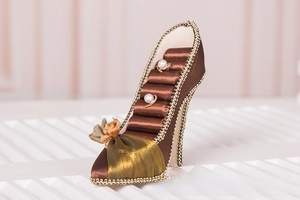 Detailed view of high heel ring display stand with brown satin and golden lace trim