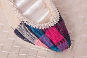 Macro shot of colorful plaid fabric shoe jewelry holder with elegant lace trim detail