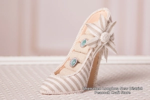 Striped high heel jewelry holder with knitted flower detail and emerald green rings