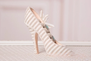 Detail view of high heel ring display stand with lace trim and blue gemstone jewelry