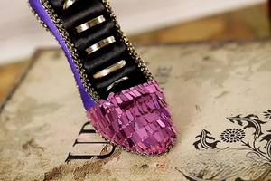 Macro view of purple satin high heel ring holder featuring sequins and lace details