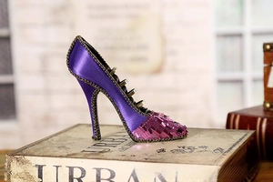 Detail of high heel ring display stand with purple satin fabric and sequin accents