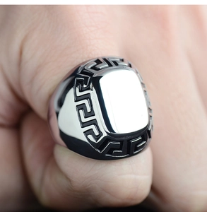 Macro detail of men's titanium steel square ring featuring a Greek fret pattern on the finger