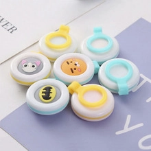 Close-up of cute cartoon animal contact lens cases in yellow, blue, and grey colors