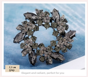 Macro shot of 5.3cm gunmetal flower wreath brooch with gray sparkling rhinestones