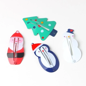 Close-up of four Christmas themed hair clips with Santa and Snowman designs