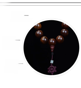 Macro detail of natural rosewood prayer beads with polished texture and silk tassel
