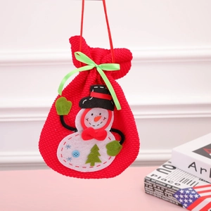 Knitted red snowman drawstring gift bag hanging in a cozy indoor setting with books