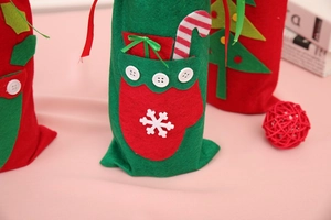 Detail of Christmas felt gift bags and wine bottle covers with festive embroidery icons