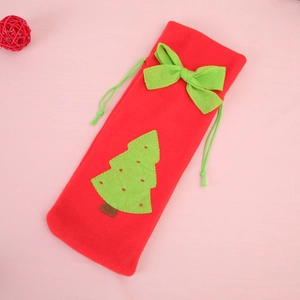 Detail of red Christmas wine bottle bag with green bow and festive tree applique