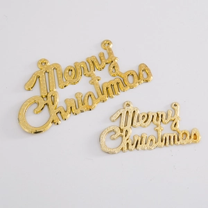 Macro shot of two golden Merry Christmas plastic letter plates with textured surface details