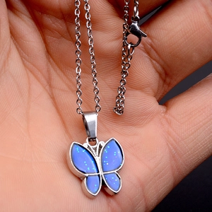 Dettaglio della collana a farfalla con ali glitterate blu e catenina in argento