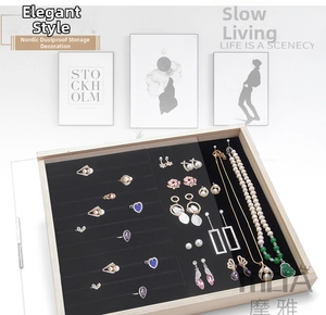 Macro detail of wooden jewelry box featuring black velvet ring slots and necklace hooks