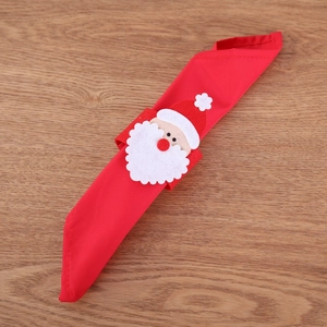 Christmas Santa Claus napkin rings made of red non-woven fabric on wooden tabletop