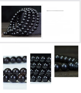 Macro detail of 108 ebony wood prayer beads showing natural grain and polished texture