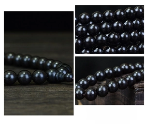 Macro detail of hand-polished 108 black ebony beads showing smooth texture and luster