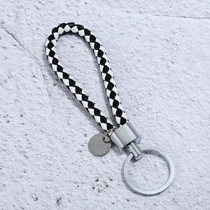 Handmade black and white braided leather keychain with polished silver metal ring
