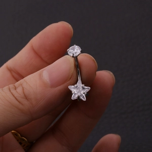 Detail shot of a 316L stainless steel belly ring with star and round cubic zirconia