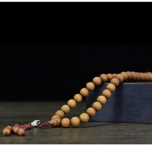 Macro detail of dark brown sandalwood prayer beads with natural wood grain and texture