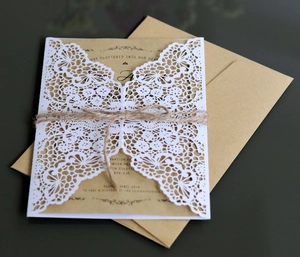 Close-up of laser-cut butterfly invitation with kraft card and natural twine details
