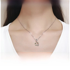Detail shot of a s925 silver bird pendant necklace worn by a model for a nature-inspired look