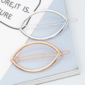 Vue détaillée des barrettes à cheveux géométriques en métal argent et or rose sur livre