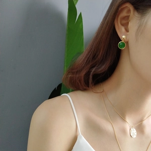 Close-up of S925 silver green agate stud earrings and layered gold coin necklace on model