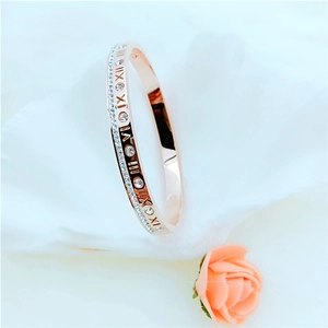 Rose gold Roman numeral bangle featuring inlaid cubic zirconia in a polished finish