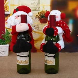 Detail view of knitted Santa and Snowman plush wine bottle covers for Christmas decor