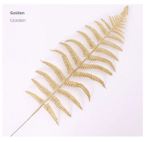 Macro shot of artificial golden glitter fern leaf with realistic texture for Christmas decor