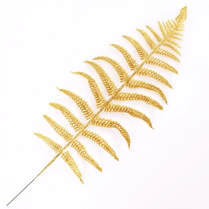 Macro detail of golden glitter fern leaf branch for Christmas tree decoration