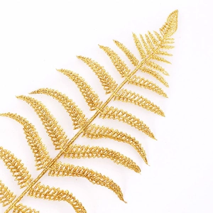 Macro detail of artificial golden fern leaf with glitter finish for Christmas decor