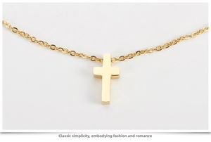 Close-up of polished rose gold cross pendant on a fine O-chain with mirror finish
