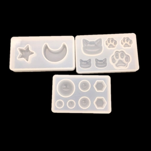 Macro detail of silicone molds showing star moon and cat paw shapes for DIY resin crafts