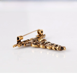 Detail view of the vintage snake brooch back showing metal texture and safety pin