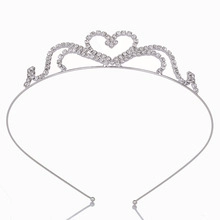 Detailed macro view of silver crown tiara featuring sparkling crystal heart and wave patterns