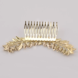 Detailed close-up of a gold metal leaf-shaped hair comb with polished vintage textures