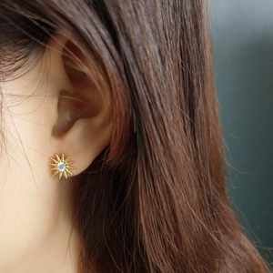 Close-up of starburst stud earrings featuring 925 silver and white zircon inlay