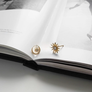 Detail of asymmetric 925 silver sun and moon stud earrings with gold plating and crystals