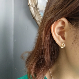 Detailed view of gold moon and star stud earring set with sparkling crystals on ear