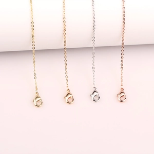 Close-up of four colors of delicate metal chains with lobster clasps in gold and silver