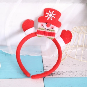 Close-up detail of a Christmas snowman headband with festive plush red hat and white snow flakes