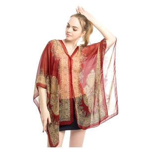 Detail of bohemian chiffon shawl with yellow paisley patterns on burgundy background